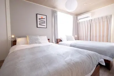 two beds in a room with a window at Belshaart Kamikitazawa - Vacation STAY 20317 in Tokyo