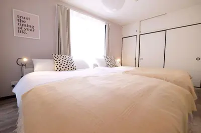 two beds in a bedroom with a large window at Belshaart Kamikitazawa - Vacation STAY 20382 in Tokyo