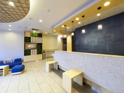 a hotel lobby with a reception counter and blue chairs at Far East Village Hotel Tokyo Asakusa - Vacation STAY 46931v in Tokyo