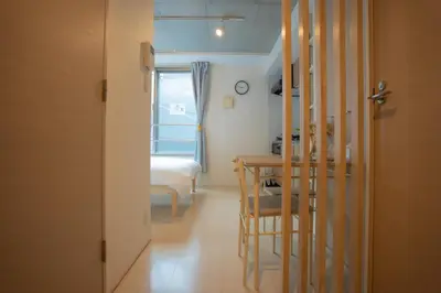 a room with a table and a bed and a window at \u30ea\u30fc\u30ac\u30e9\u30f3\u30c9\u30d6\u30e9\u30f3\u5927\u585a in Tokyo