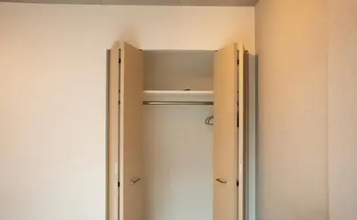 a closet with wooden cabinets and a door in a room at \u30ea\u30fc\u30ac\u30e9\u30f3\u30c9\u30d6\u30e9\u30f3\u5927\u585a in Tokyo