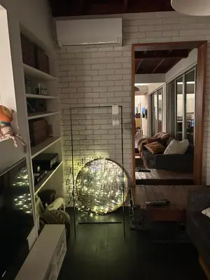 a living room with a mirror and a chair at Shimokitazawa Sanctuary , Spacious Stay for Families & Romantic Getaways in Tokyo