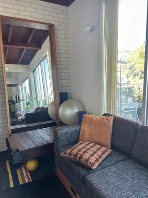 a living room with a couch and a mirror at Shimokitazawa Sanctuary , Spacious Stay for Families & Romantic Getaways in Tokyo