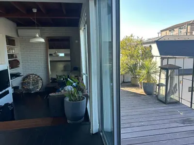 an open sliding glass door of a porch with potted plants at Shimokitazawa Sanctuary , Spacious Stay for Families & Romantic Getaways in Tokyo