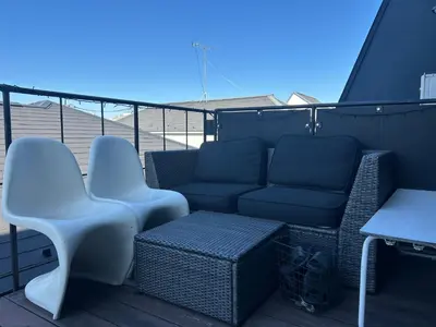 a patio with a couch and chairs on a deck at Shimokitazawa Sanctuary , Spacious Stay for Families & Romantic Getaways in Tokyo