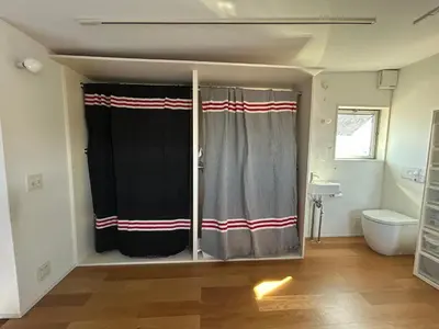 a bathroom with a shower curtain and a toilet at Shimokitazawa Sanctuary , Spacious Stay for Families & Romantic Getaways in Tokyo