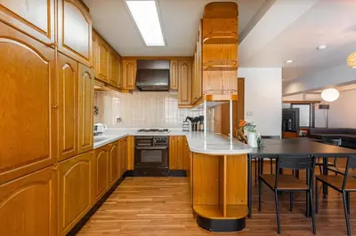 a kitchen with wooden cabinets and a table with chairs at \u671f\u9593\u9650\u5b9a \u6d45\u8349\u6a4b3floor in Tokyo