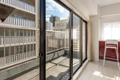 a balcony with sliding glass doors and a chair at \u671f\u9593\u9650\u5b9a \u6d45\u8349\u6a4b4floor in Tokyo
