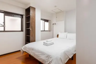 a bedroom with a white bed and a window at \u671f\u9593\u9650\u5b9a \u6d45\u8349\u6a4b4floor in Tokyo