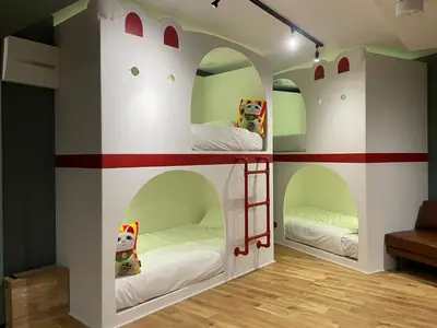 a room with two bunk beds in a house at Tokyo Manekineko Stay \u62db\u304d\u732b\u3067\u6709\u540d\u306a\u8c6a\u5fb3\u5bfa\u99c5\u304b\u3089\u5f92\u6b699\u5206 \u30a2\u30fc\u30c6\u30a3\u30b9\u30c8\u5236\u4f5c\u306e\u62db\u304d\u732b\u30d9\u30c3\u30c9\u306e\u4e2d\u306b\u6cca\u307e\u308c\u308b\u5bbf in Tokyo