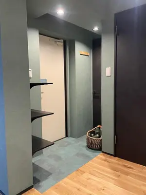 a hallway with a door and a basket on the floor at Tokyo Manekineko Stay \u62db\u304d\u732b\u3067\u6709\u540d\u306a\u8c6a\u5fb3\u5bfa\u99c5\u304b\u3089\u5f92\u6b699\u5206 \u30a2\u30fc\u30c6\u30a3\u30b9\u30c8\u5236\u4f5c\u306e\u62db\u304d\u732b\u30d9\u30c3\u30c9\u306e\u4e2d\u306b\u6cca\u307e\u308c\u308b\u5bbf in Tokyo