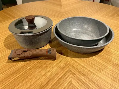 a bowl sitting on a wooden table with a spatula at Tokyo Manekineko Stay \u62db\u304d\u732b\u3067\u6709\u540d\u306a\u8c6a\u5fb3\u5bfa\u99c5\u304b\u3089\u5f92\u6b699\u5206 \u30a2\u30fc\u30c6\u30a3\u30b9\u30c8\u5236\u4f5c\u306e\u62db\u304d\u732b\u30d9\u30c3\u30c9\u306e\u4e2d\u306b\u6cca\u307e\u308c\u308b\u5bbf in Tokyo