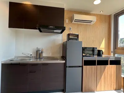 a kitchen with a refrigerator and a sink at Tokyo Gallery Stay \u99c51\u5206\u3067\u8cb8\u5207 8\u4ebaOK\u306e\u30a2\u30fc\u30c6\u30a3\u30b9\u30c8\u5236\u4f5c\u306e\u30d9\u30c3\u30c9 \u685c\u3092\u898b\u4e0b\u308d\u305b\u308b\u90e8\u5c4b \u5546\u5e97\u8857\u3067\u8cd1\u3084\u304b in Tokyo