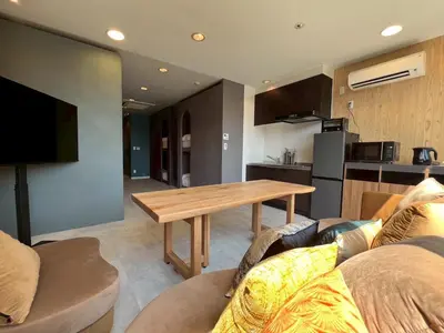a living room with a table and a kitchen at Tokyo Gallery Stay \u99c51\u5206\u3067\u8cb8\u5207 8\u4ebaOK\u306e\u30a2\u30fc\u30c6\u30a3\u30b9\u30c8\u5236\u4f5c\u306e\u30d9\u30c3\u30c9 \u685c\u3092\u898b\u4e0b\u308d\u305b\u308b\u90e8\u5c4b \u5546\u5e97\u8857\u3067\u8cd1\u3084\u304b in Tokyo