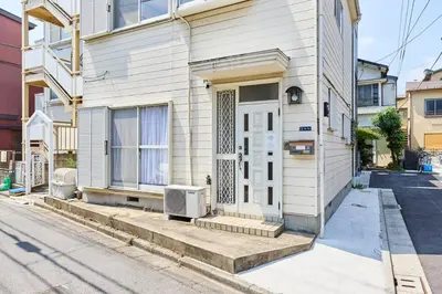 a white house with a door on a street at Yik\u7acb\u82b12\u4e01\u76ee in Tokyo