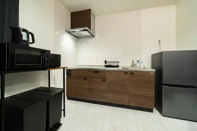a kitchen with a microwave and a refrigerator at \u5225\u90b8Zen\u5c0f\u5ca9 Bettei Zen Koiwa in Tokyo