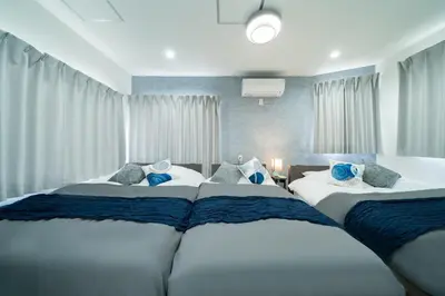 a bedroom with two beds with blue and white at \u5225\u90b8Zen\u5c0f\u5ca9 Bettei Zen Koiwa in Tokyo