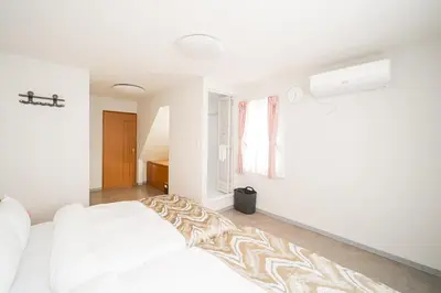 a white bedroom with a bed and a window at Spacious 3-Story House with 2 Baths, 7 min to Metro direct to Akihabara Ueno Ginza in Tokyo