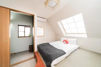a bedroom with a bed with a red stuffed animal on it at Spacious 3-Story House with 2 Baths, 7 min to Metro direct to Akihabara Ueno Ginza in Tokyo