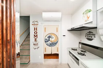 a kitchen with white walls and a staircase at Spacious 3-Story House with 2 Baths, 7 min to Metro direct to Akihabara Ueno Ginza in Tokyo