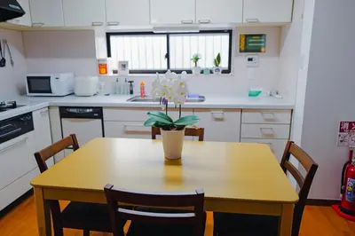 a kitchen with a wooden table with a vase of flowers on it at Akira Hiro House - Room203 in Tokyo