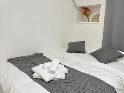 a white bed with a pile of towels on it at Shinjuku Waseda B2 in Tokyo