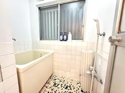 a bathroom with a tub and a tile floor at Shinjuku Waseda B2 in Tokyo