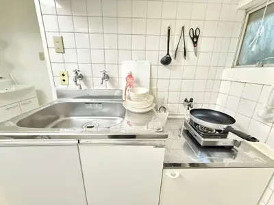 a white kitchen with a sink and a stove at Shinjuku Waseda B2 in Tokyo