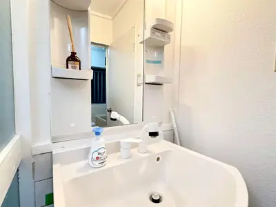 a white bathroom with a sink and a mirror at Shinjuku Waseda B2 in Tokyo