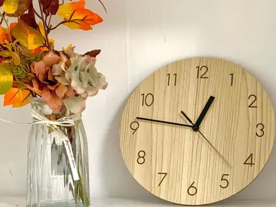 a clock on a wall next to a vase with flowers at Shinjuku Waseda B2 in Tokyo