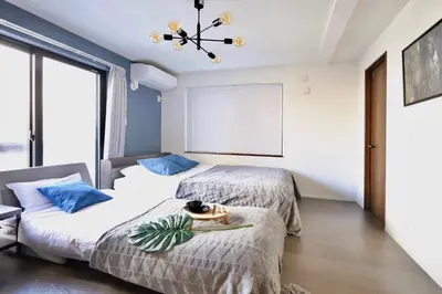 two beds in a room with a window at \u6e0b\u8c37\u30c6\u30e9\u30b9 \u6e0b\u8c37\u99c5\u5f92\u6b697\u5206 \u9ad8\u7d1a\u30de\u30f3\u30b7\u30e7\u30f3 \u30c6\u30e9\u30b9\u773a\u671b\u629c\u7fa4 in Tokyo