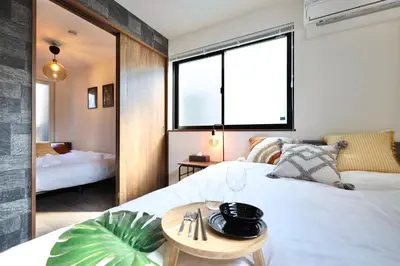 a bedroom with a large white bed and a window at \u6e0b\u8c37\u30c6\u30e9\u30b9 \u6e0b\u8c37\u99c5\u5f92\u6b697\u5206 \u9ad8\u7d1a\u30de\u30f3\u30b7\u30e7\u30f3 \u30c6\u30e9\u30b9\u773a\u671b\u629c\u7fa4 in Tokyo