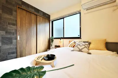 a bedroom with a large white bed and a window at \u6e0b\u8c37\u30c6\u30e9\u30b9 \u6e0b\u8c37\u99c5\u5f92\u6b697\u5206 \u9ad8\u7d1a\u30de\u30f3\u30b7\u30e7\u30f3 \u30c6\u30e9\u30b9\u773a\u671b\u629c\u7fa4 in Tokyo