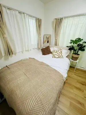 a bedroom with a large bed with a large window at 5-minute walk from Otsuka Station on the Yamanote Line, 20 square meters On the 3rd floor No elevator in Tokyo