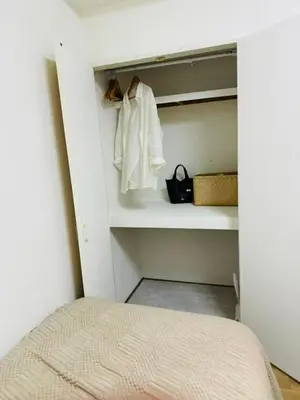 a bedroom with a bed and a white robe on a shelf at 5-minute walk from Otsuka Station on the Yamanote Line, 20 square meters On the 3rd floor No elevator in Tokyo