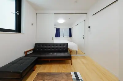 a black leather couch in a room with a bedroom at Convertel Setagaya - Vacation STAY 45940v in Tokyo