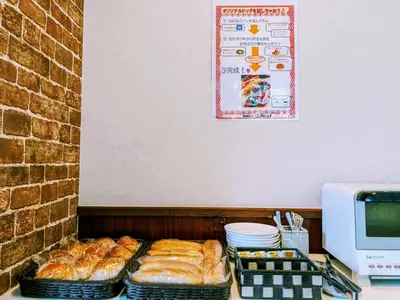 a counter with several baskets of pastries on a table at Smile Hotel Tokyo Ayase Ekimae - Vacation STAY 62847v in Tokyo