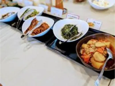 a table with plates of food and a pan of food at Smile Hotel Tokyo Ayase Ekimae - Vacation STAY 62863v in Tokyo