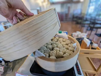 a person is cooking food in a pot at Smile Hotel Tokyo Ayase Ekimae - Vacation STAY 62863v in Tokyo