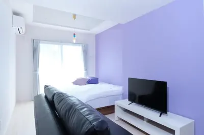 a living room with a couch and a flat screen tv at Metro Gate MORISHITA 301-401-501 - Vacation STAY 16701v in Tokyo