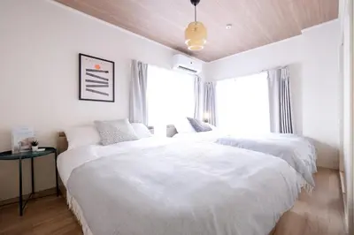 two beds in a white bedroom with a window at Belshaart Kamikitazawa - Vacation STAY 20402 in Tokyo