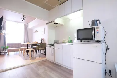a kitchen with white cabinets and a microwave at Belshaart Kamikitazawa - Vacation STAY 20402 in Tokyo