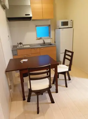 a kitchen with a table and two chairs and a refrigerator at K,AND,M,OOIMACHI - Vacation STAY 60966v in Tokyo