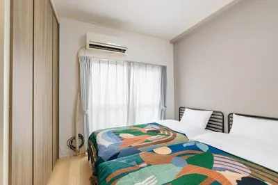 a bedroom with a bed with a colorful blanket at 10-minute walk from Nakano Station Studio apartment \u5c0f\u677e\u30d3\u30eb31 in Tokyo