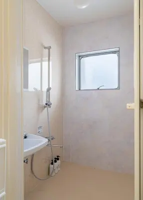 a bathroom with a shower and a sink and a window at 10-minute walk from Nakano Station Studio apartment \u5c0f\u677e\u30d3\u30eb31 in Tokyo