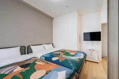 a bedroom with a bed and a flat screen tv at 10-minute walk from Nakano Station Studio apartment \u5c0f\u677e\u30d3\u30eb31 in Tokyo