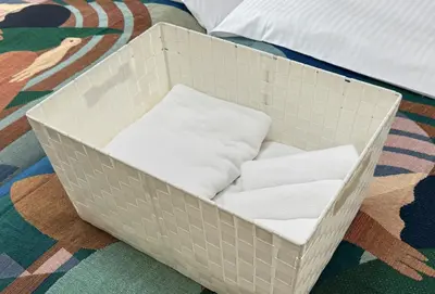 a white crate filled with towels on a bed at 10-minute walk from Nakano Station Studio apartment \u5c0f\u677e\u30d3\u30eb31 in Tokyo