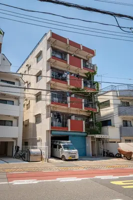 a tall building with a van parked in front of it at 10-minute walk from Nakano Station Studio apartment \u5c0f\u677e\u30d3\u30eb31 in Tokyo