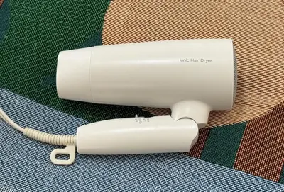a white hair dryer with a cord plugged into it at 10-minute walk from Nakano Station Studio apartment \u5c0f\u677e\u30d3\u30eb31 in Tokyo