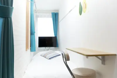 a small room with a bed and a desk and a chair at Zenith Shinjuku Hinoki Building B by Tranova in Tokyo